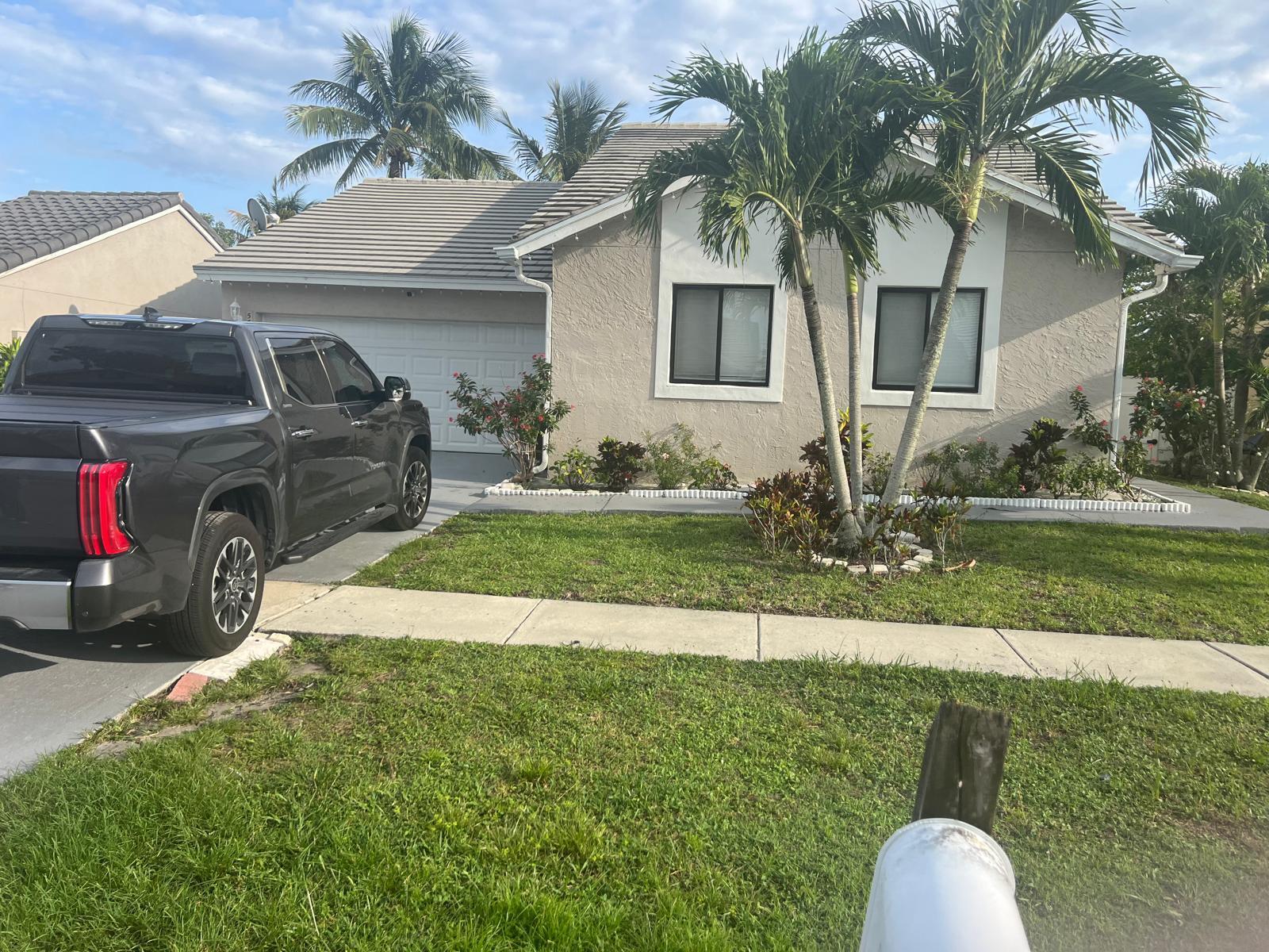 A single-story house with a gray truck parked in the driveway and palm trees — 5765 Strawberry Lakes Circle, Lake Worth FL 33463, LAKE WORTH, FL