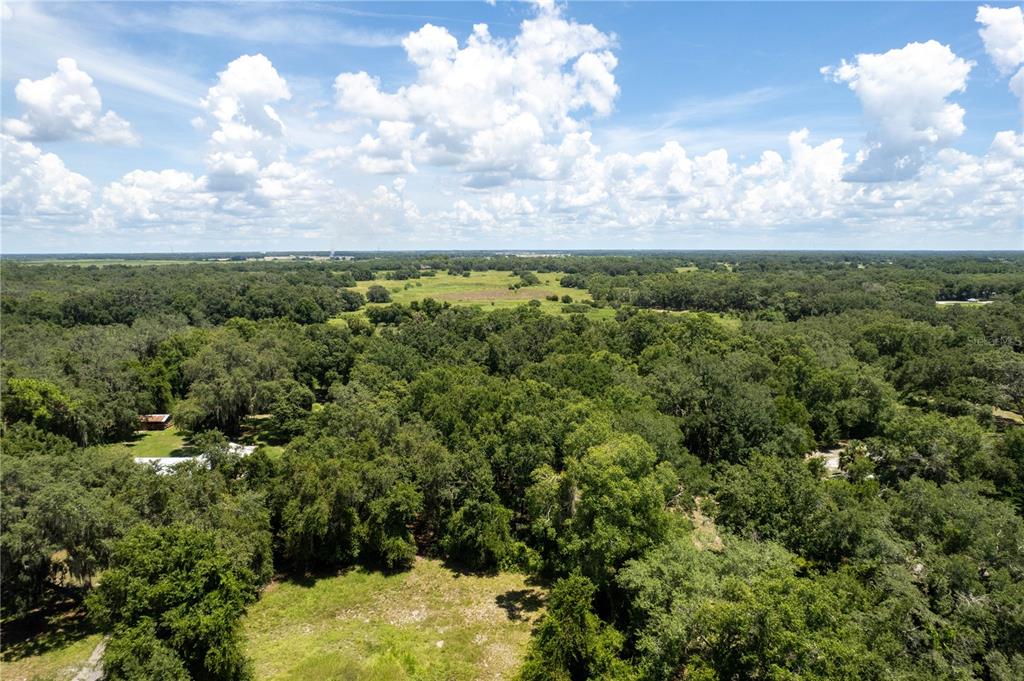 An aerial view shows a large, wooded rural property with a small house and clearing — 2951 SEMINOLE ROAD, ST CLOUD, FL