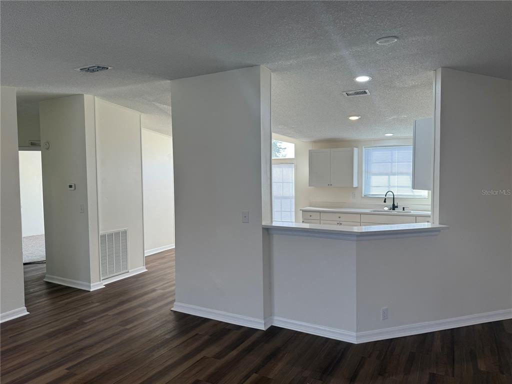 A view from a living area looking into a kitchen with white cabinets and counters — 4795 SCHOONER AVENUE, LAKE WALES, FL