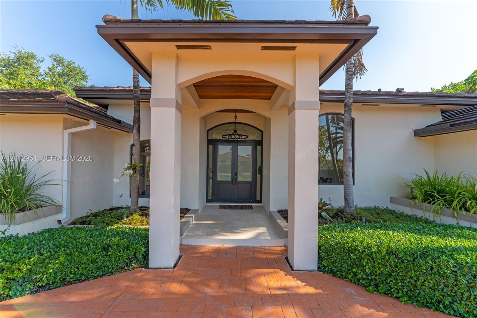 The exterior of a house features a covered entryway with double doors and brick pavers — 12019 SW 77th Ter, Miami FL 33183, MIAMI, FL
