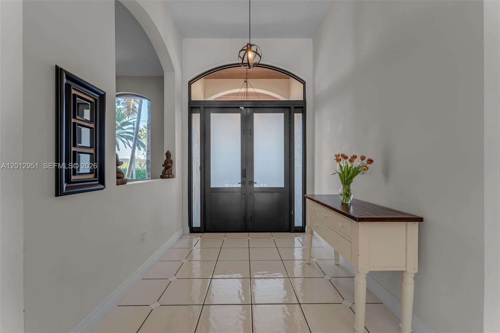 A bright entryway features a double door, tile flooring, and a wooden console table — 12019 SW 77th Ter, Miami FL 33183, MIAMI, FL