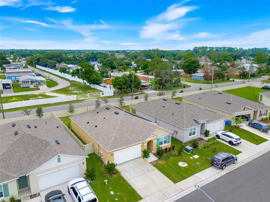 An aerial view shows several suburban houses with driveways and lawns in a residential neighborhood — 3041 TOBAGO DRIVE, HAINES CITY, FL