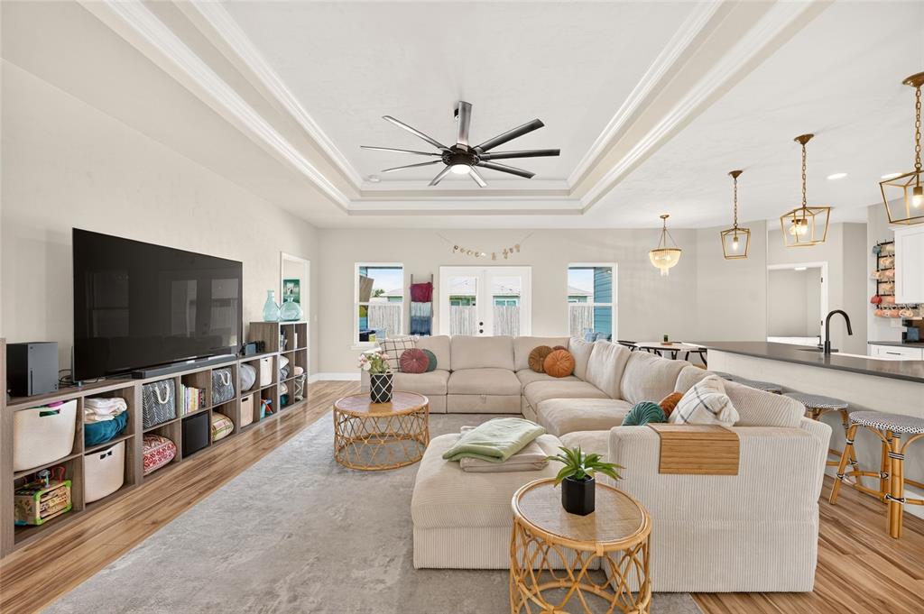 A living room features a large sectional sofa, a television console, and a tray ceiling — 23038 NW 4TH PLACE, NEWBERRY, FL