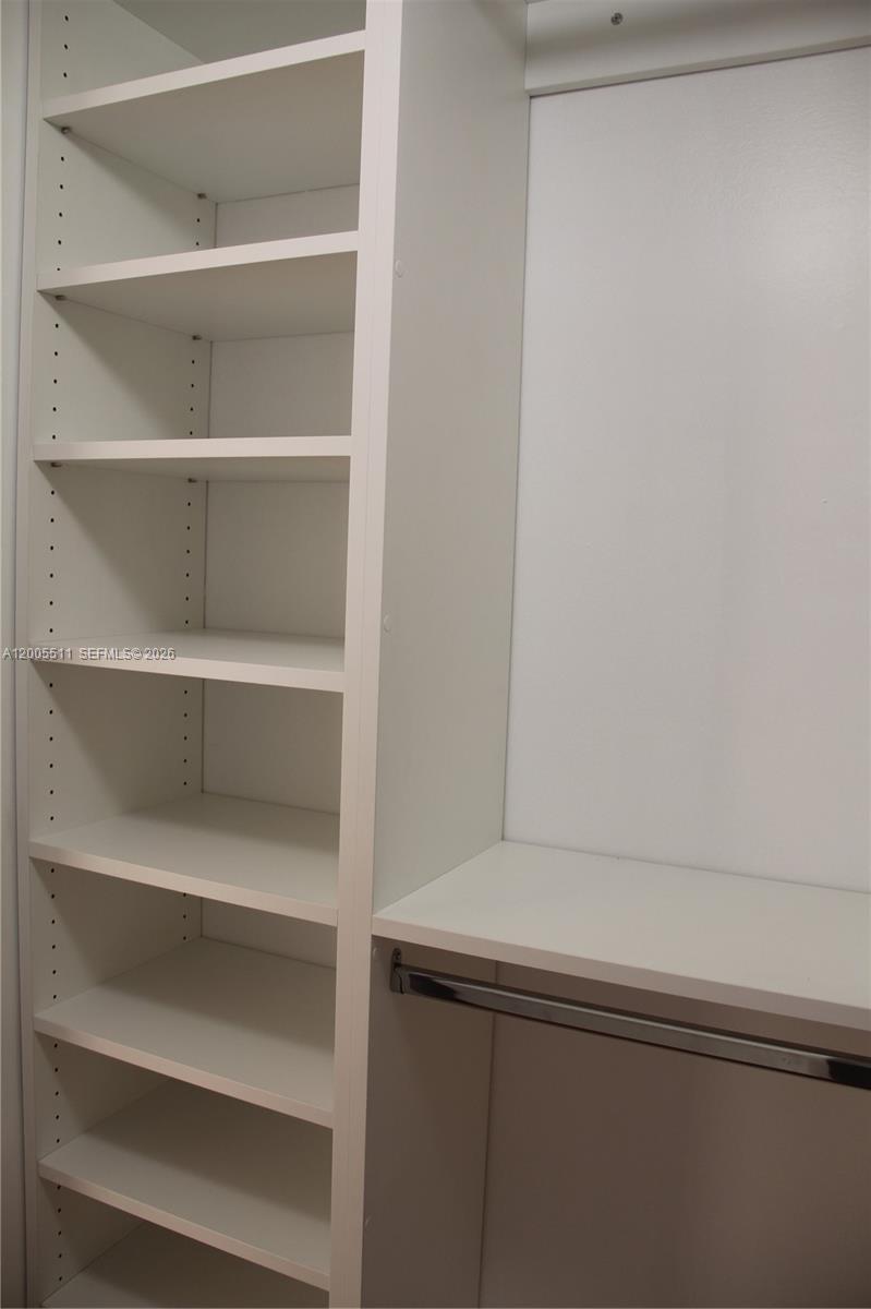 A walk-in closet features white shelving, hanging rods, and a set of drawers — 8700 SW 133rd Ave Rd # 301, Miami FL 33183, MIAMI, FL
