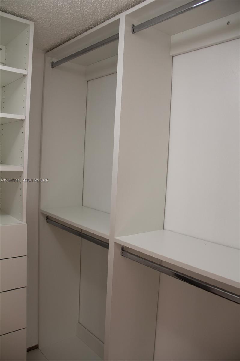 A walk-in closet features white shelving, a five-drawer dresser, and hanging rods — 8700 SW 133rd Ave Rd # 301, Miami FL 33183, MIAMI, FL