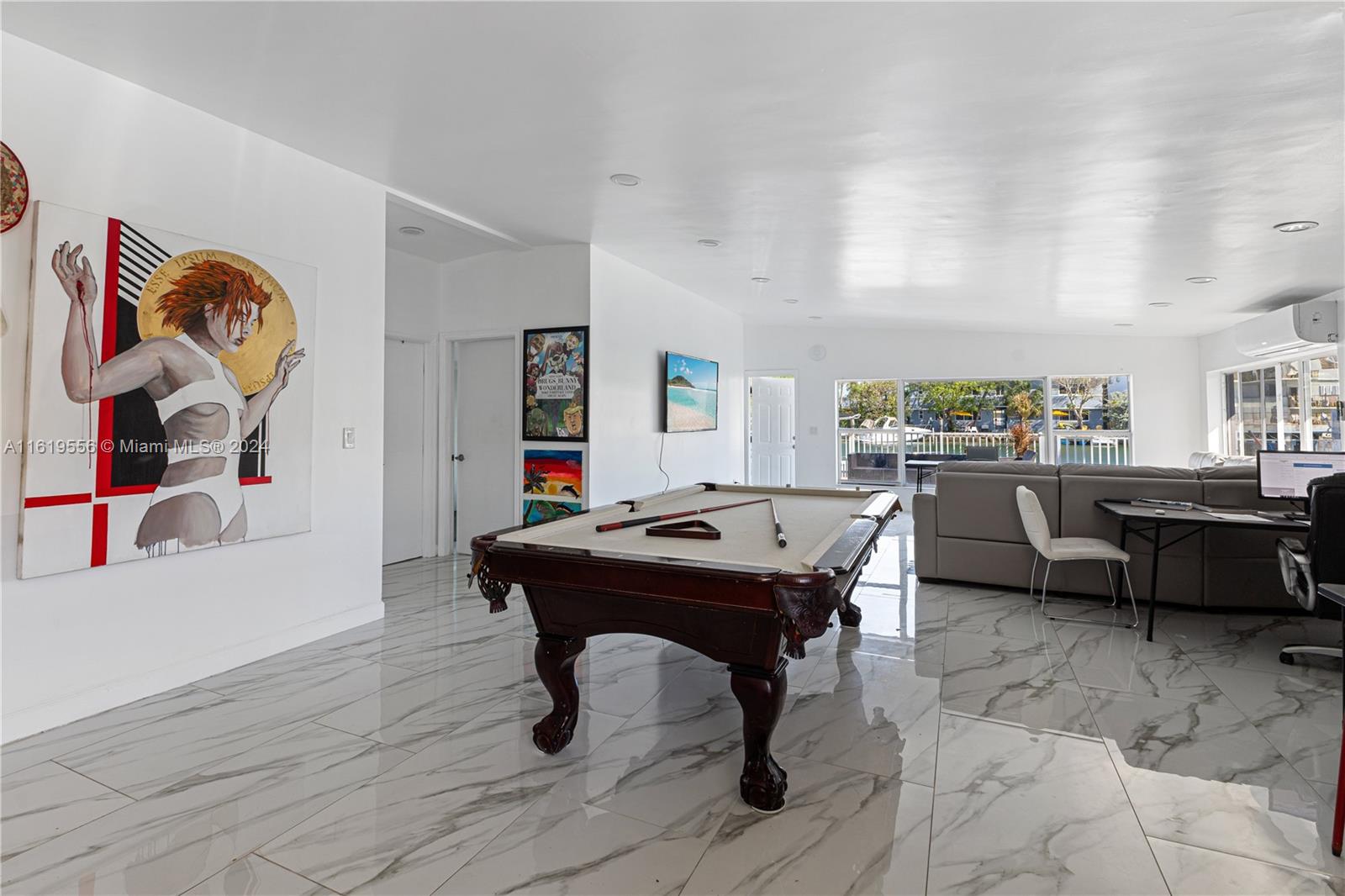 A living room features a pool table, white marble-style flooring, and a large wall painting — 8221 Crespi Blvd, Miami Beach FL 33141, MIAMI BEACH, FL