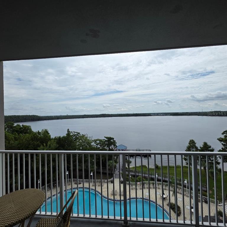 A balcony view overlooking a swimming pool, a wooden pier, and a large lake — 13415 BLUE HERON BEACH DRIVE UNIT 609, ORLANDO, FL