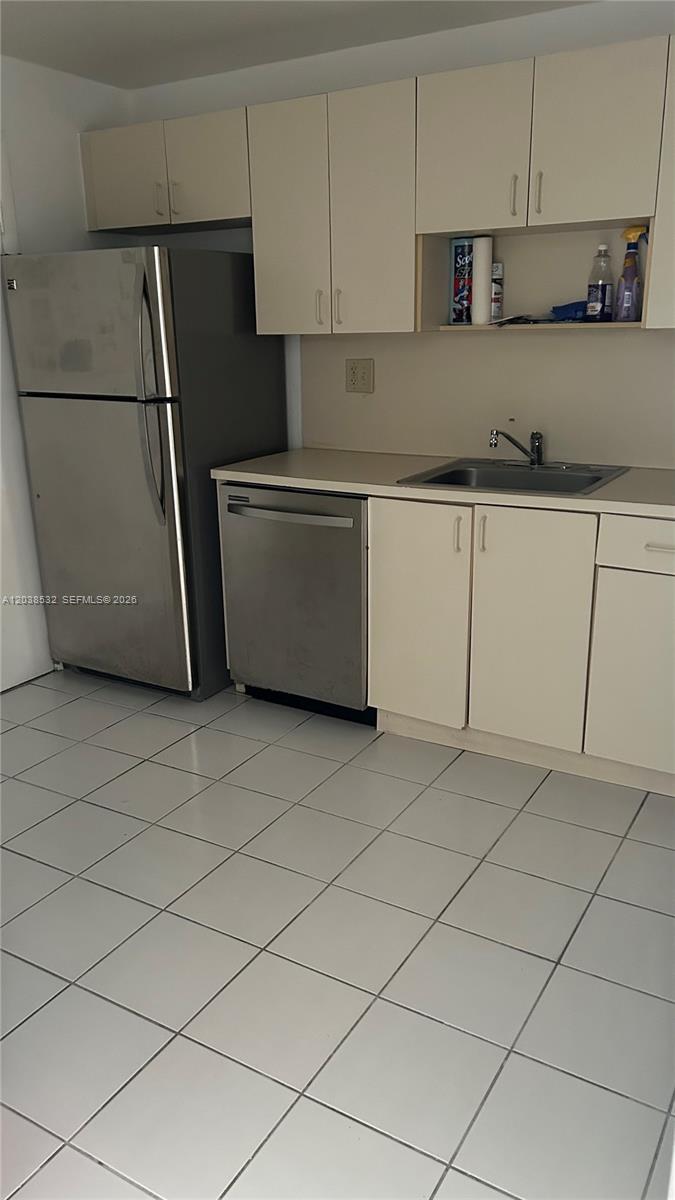 A kitchen features white cabinets, stainless steel appliances, a sink, and white floor tiles — 9962 N KENDALL DR # 7, Miami FL 33176, MIAMI, FL