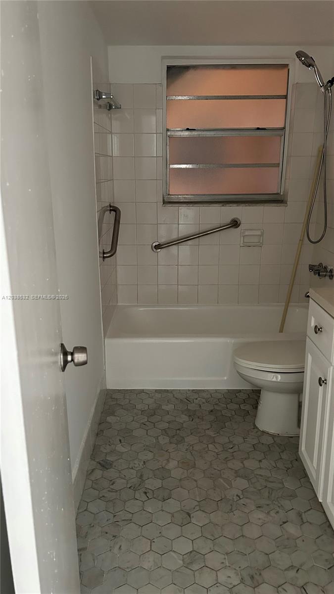 A bathroom features a white bathtub, a toilet, and gray hexagonal floor tiles — 9962 N KENDALL DR # 7, Miami FL 33176, MIAMI, FL