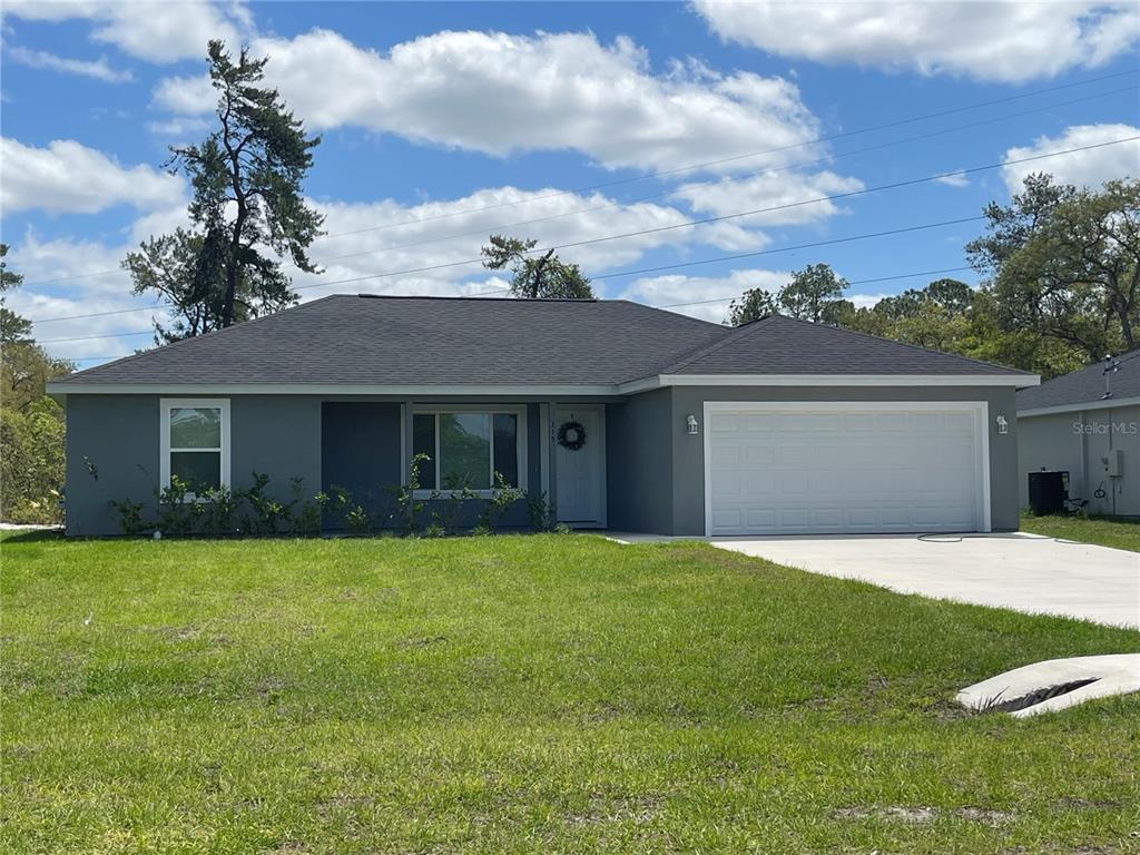 A paved road sits in front of a grassy lot backed by a dense forest — 200 FISHER ROAD, OCKLAWAHA, FL