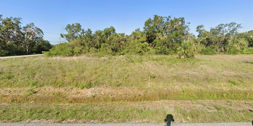 A vacant, grassy lot with a dense line of trees and shrubs in the background — Lot 1, 2, 3 & 4 ANTONIO STREET, NORTH PORT, FL