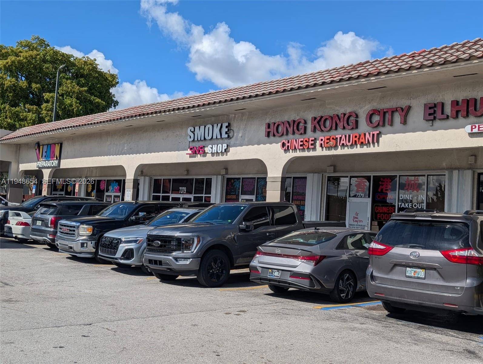 A row of commercial storefronts features a smoke shop and a Chinese restaurant with parked cars — 7373 NW 36th St, Miami FL 33166, MIAMI, FL