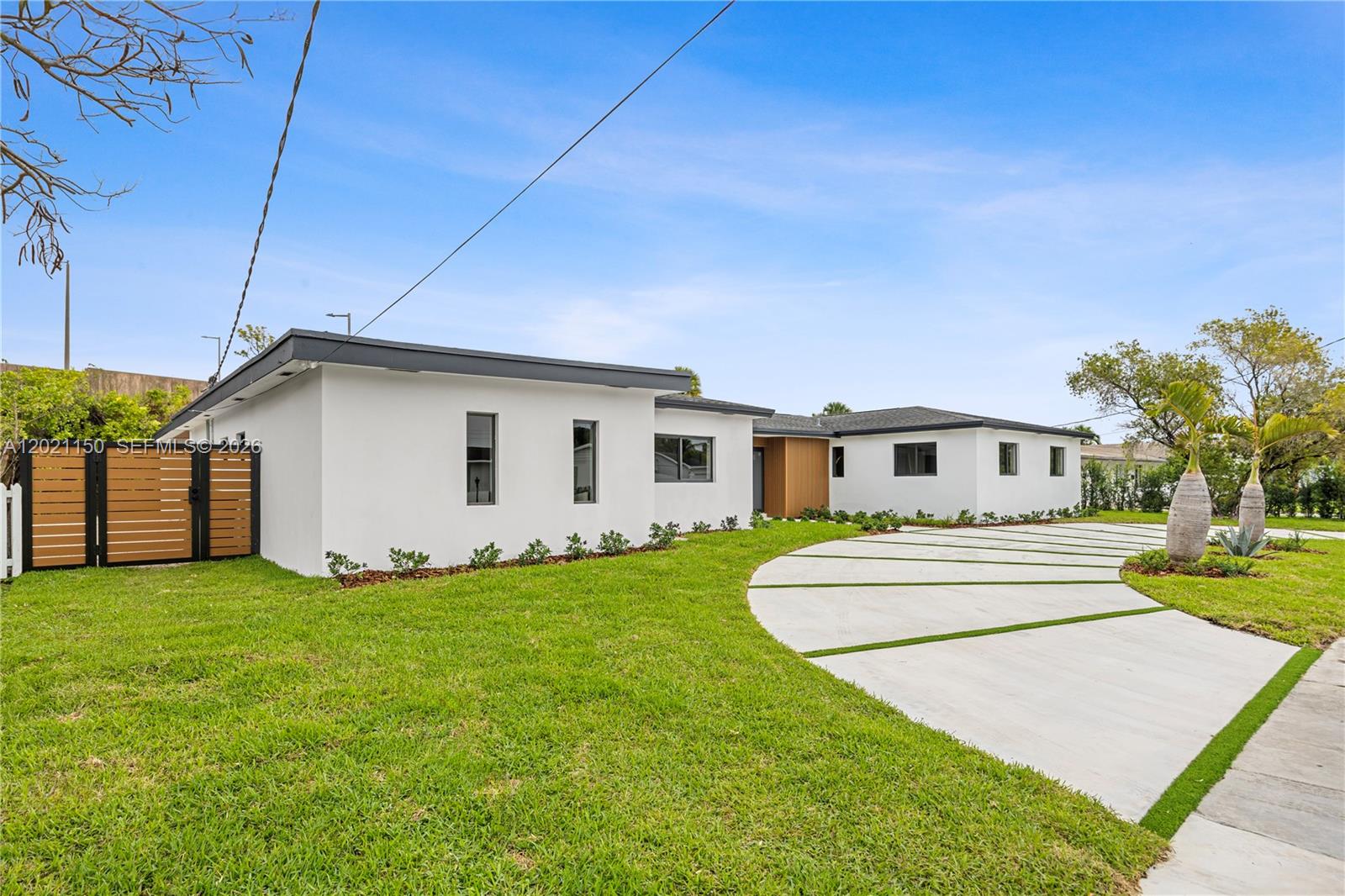 A white, single-story house with a curved concrete driveway and a wooden gate — 9261 SW 80th Ter, Miami FL 33173, MIAMI, FL