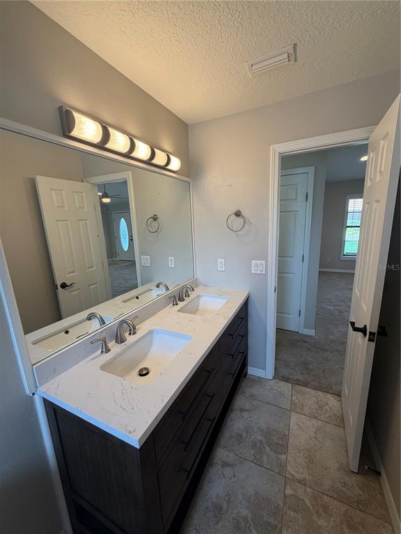 A bathroom features a double-sink vanity with a white marble countertop and dark cabinetry — 5741 SE 21ST LANE, OCALA, FL
