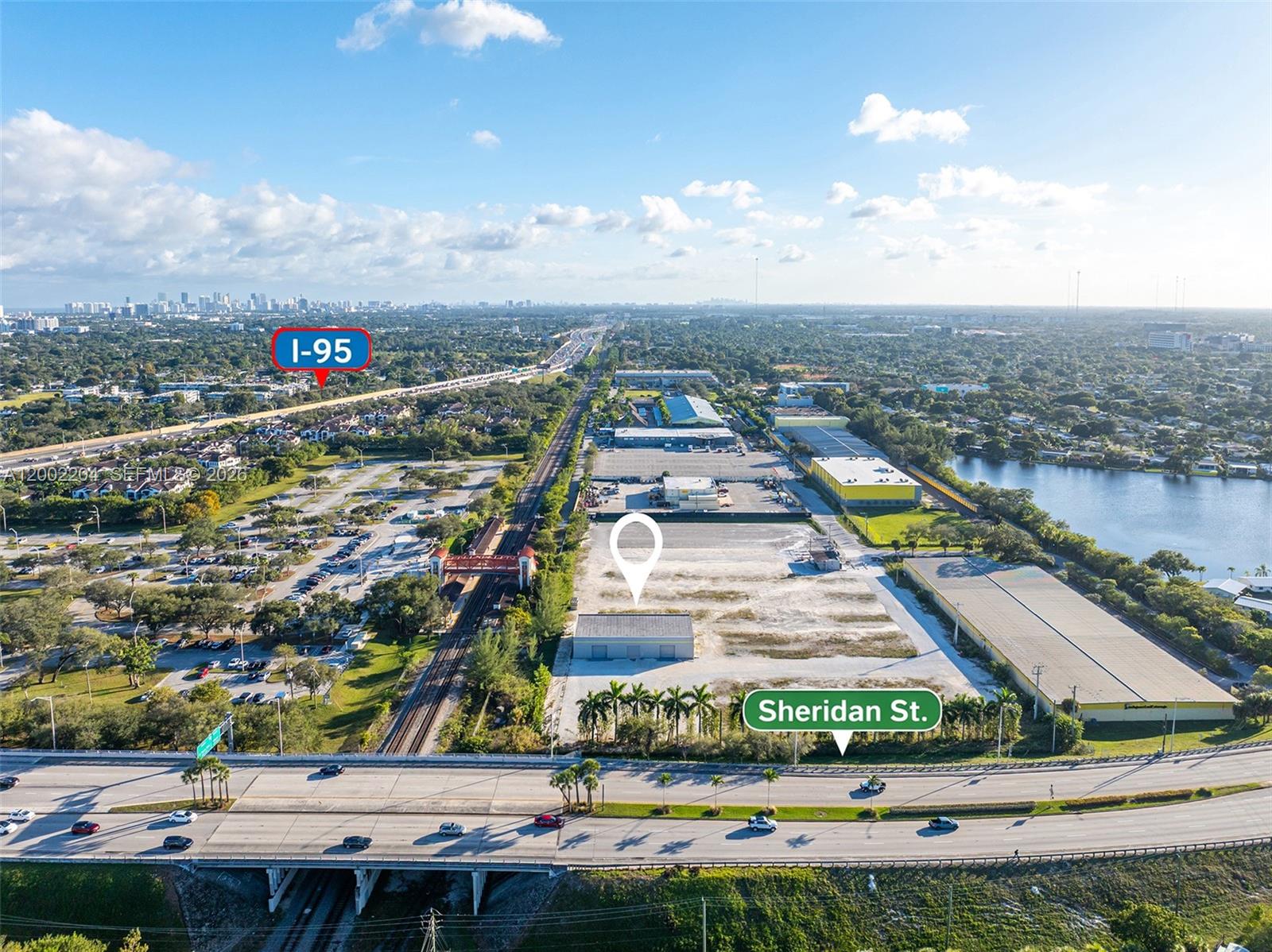 This aerial view shows a vacant lot next to railroad tracks and Sheridan Street — 3080 Sheridan St Warehouse + Office, Hollywood FL 33020, HOLLYWOOD, FL