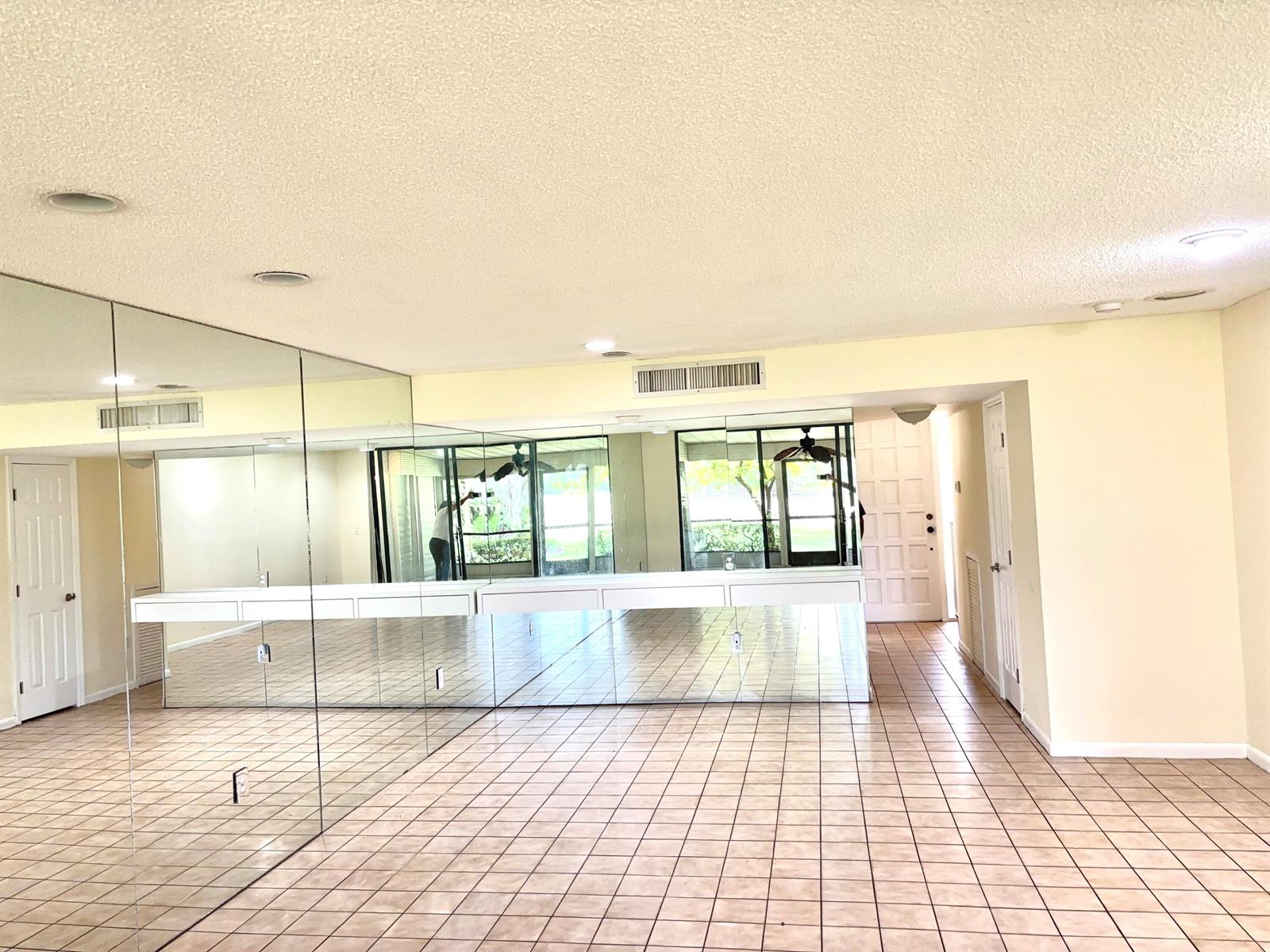A room with tiled floors, a mirrored wall, and a built-in white shelf — 4807 Esedra Court, Lake Worth FL 33467, LAKE WORTH, FL