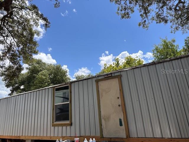 An exterior view of a mobile home with metal siding, a single door, and one window — 6631 CELESTE LANE, NEW PORT RICHEY, FL