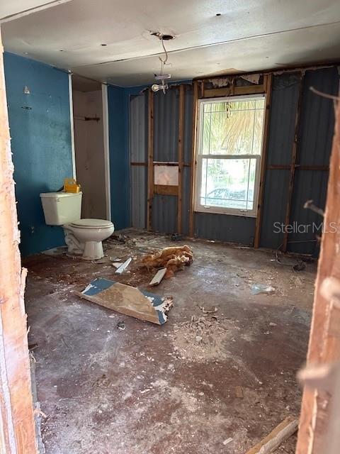 An unfinished room with exposed wall studs, a toilet, and debris on the floor — 6631 CELESTE LANE, NEW PORT RICHEY, FL