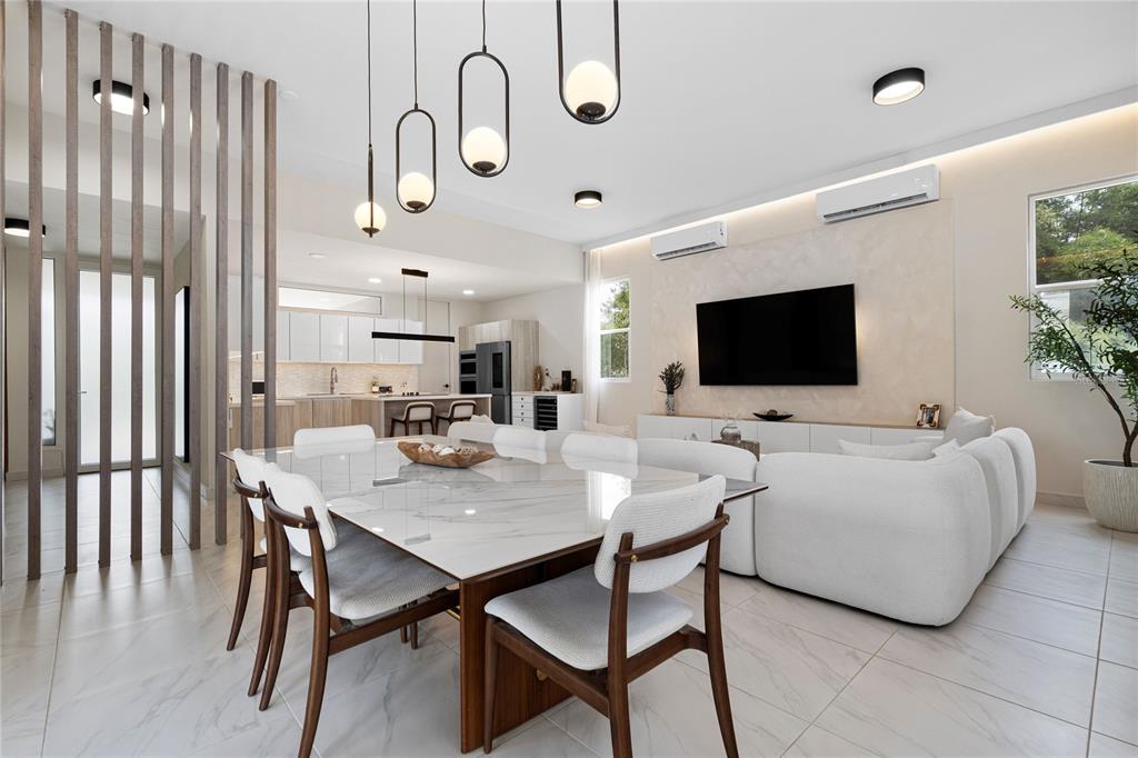 A modern open-concept living and dining area features a marble table, white sofa, and pendant lights — 153 RIVER TERRACE, JUNCOS, PR