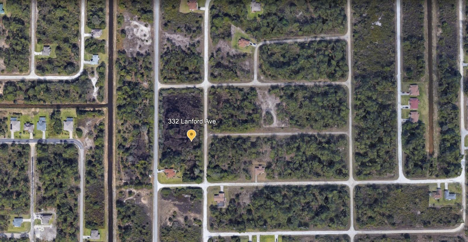 This aerial map view shows a wooded residential lot surrounded by roads and other properties — 332 Lanford Avenue, FL 33974, FL