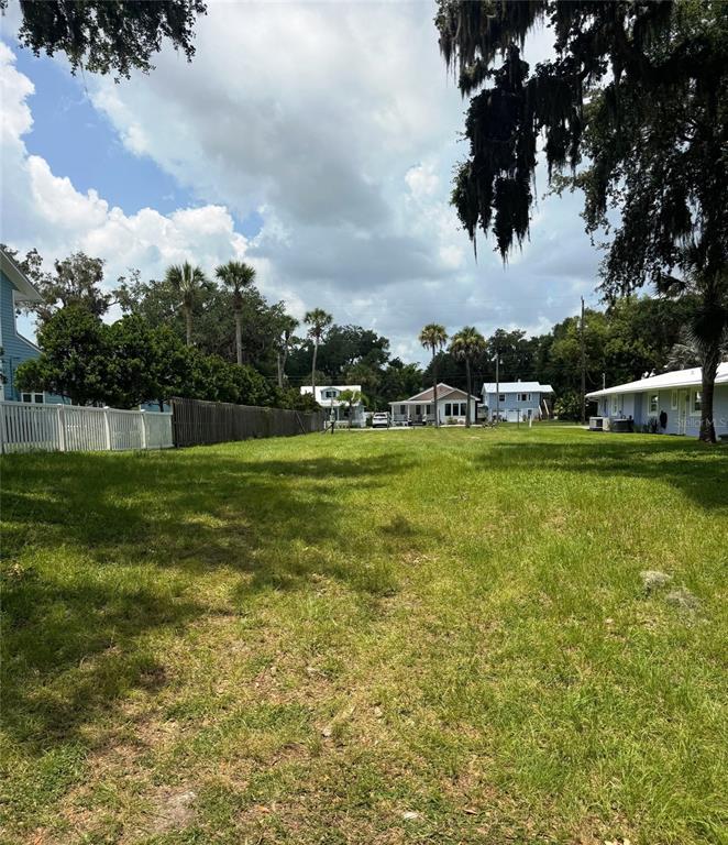 A grassy vacant lot is bordered by a white fence and several neighboring houses — 622 N RIVERSIDE DRIVE, NEW SMYRNA BEACH, FL