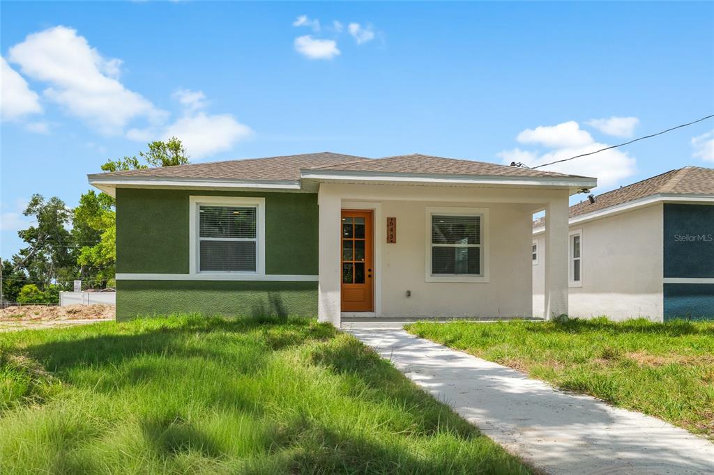 A single-story house features a green and white exterior with a covered front porch — 643 W 9TH STREET, LAKELAND, FL