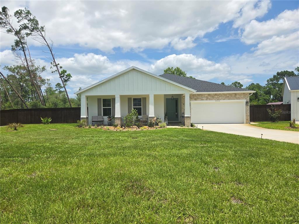 A single-story house with a white exterior, attached garage, and a separate detached garage — 30658 EAST BLUEBELL AVE, EUSTIS, FL