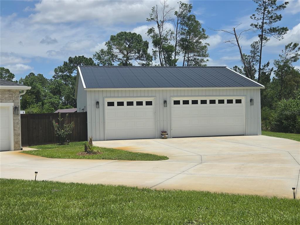 A single-story house with a white board-and-batten facade, stone accents, and a front porch — 30658 EAST BLUEBELL AVE, EUSTIS, FL