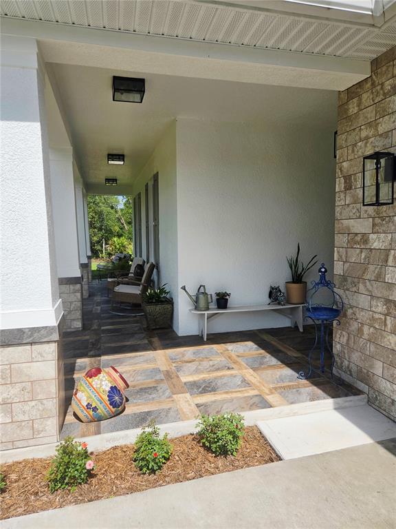 A detached metal garage with two white doors sits on a concrete driveway — 30658 EAST BLUEBELL AVE, EUSTIS, FL