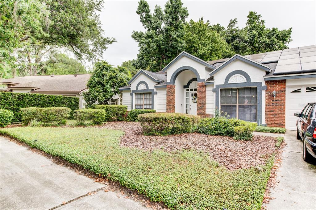 A single-story house with a brick and white exterior, arched entryway, and a front lawn — 1022 SILCOX BRANCH CIRCLE, OVIEDO, FL