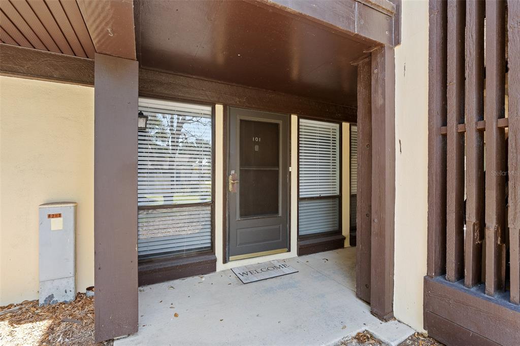 A front entrance to a residential unit features a dark door, windows, and a welcome mat — 42 CLUB HOUSE DRIVE UNIT 101, PALM COAST, FL