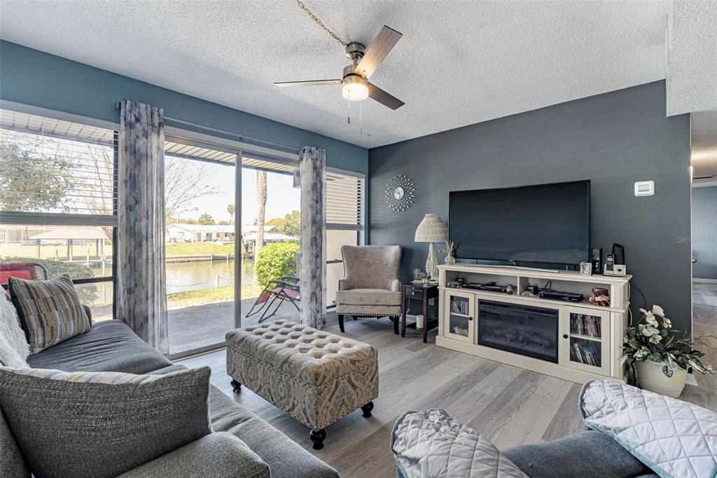 A living room features a gray accent wall, a fireplace console, and sliding glass doors — 42 CLUB HOUSE DRIVE UNIT 101, PALM COAST, FL
