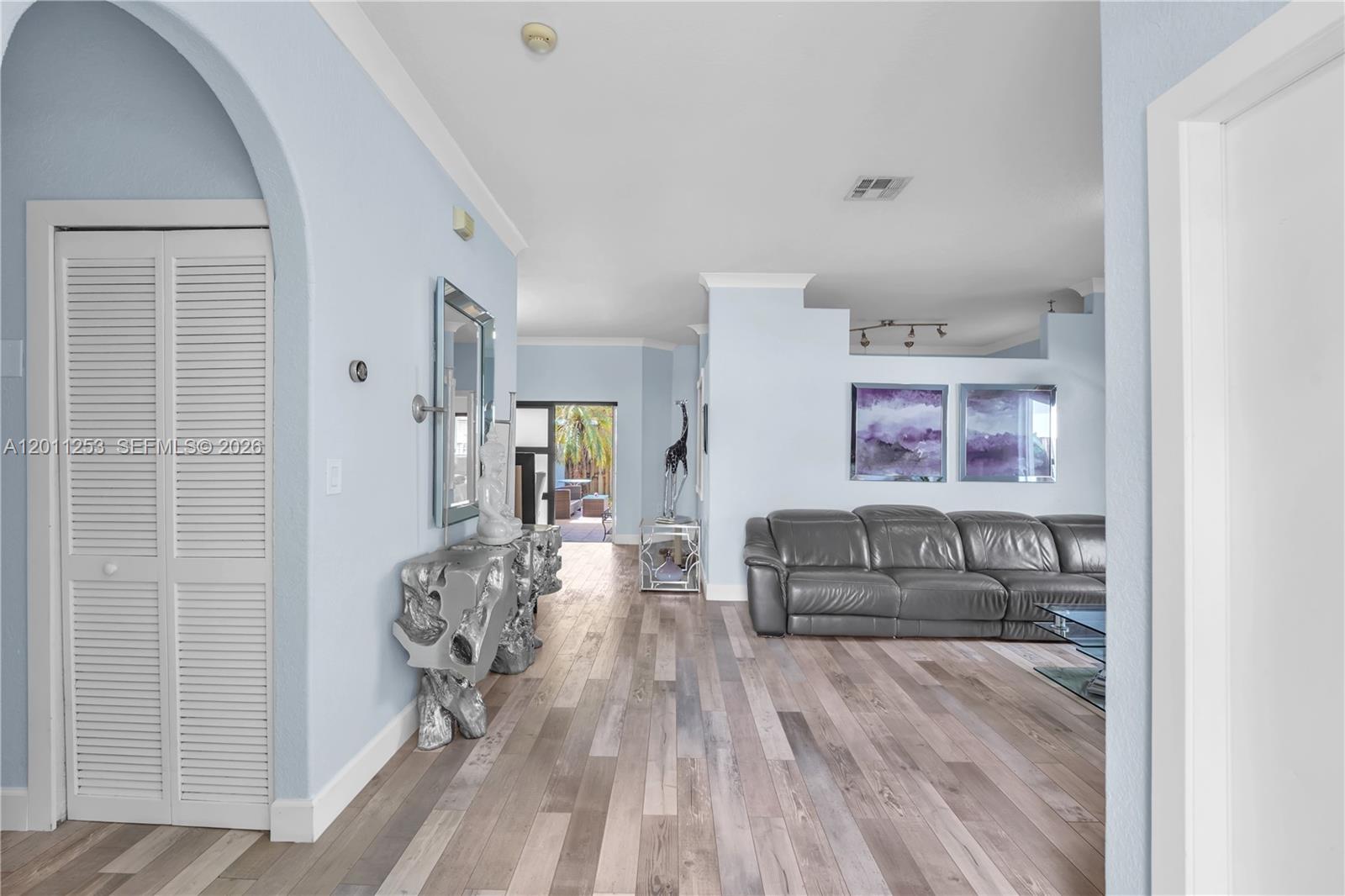 A light blue hallway leads to a living area with wood floors and a sofa — 16266 SW 54th Ter # 0, Miami FL 33185, MIAMI, FL