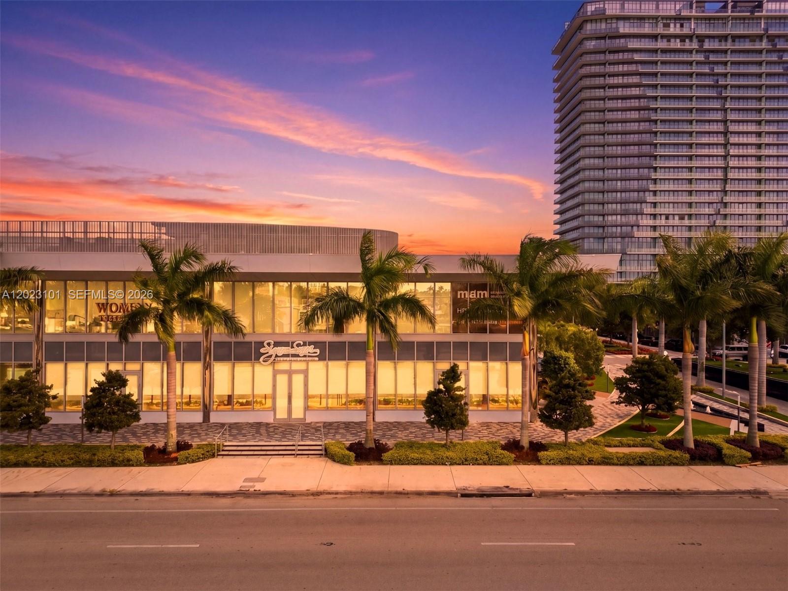 An exterior view of a modern two-story commercial building with palm trees at sunset — 1006 E Hallandale Beach Blvd # 103, Hallandale Beach FL 33009, HALLANDALE BEACH, FL