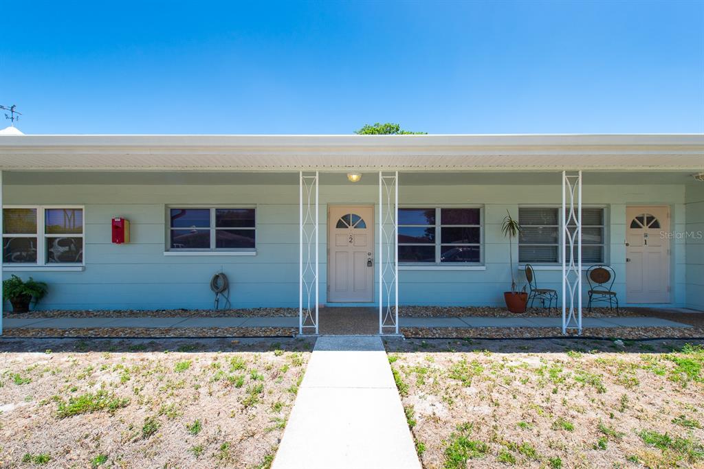 A light blue single-story building exterior features two front doors, windows, and a covered walkway — 3775 59TH STREET N UNIT 2, ST PETERSBURG, FL