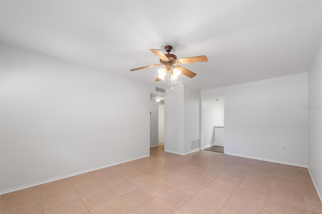 An empty room with light-colored tile flooring, white walls, and a ceiling fan — 3775 59TH STREET N UNIT 2, ST PETERSBURG, FL