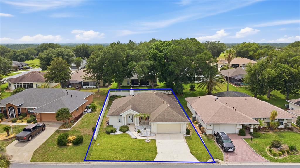 An aerial view shows a single-story house with a tan roof and a concrete driveway — 5133 LINKS LANE, LEESBURG, FL