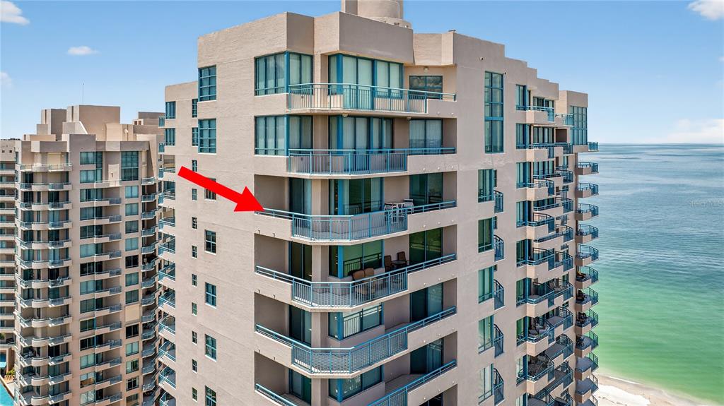 An exterior view of a high-rise residential building featuring multiple balconies overlooking the ocean — 1540 GULF BOULEVARD UNIT 2107, CLEARWATER BEACH, FL