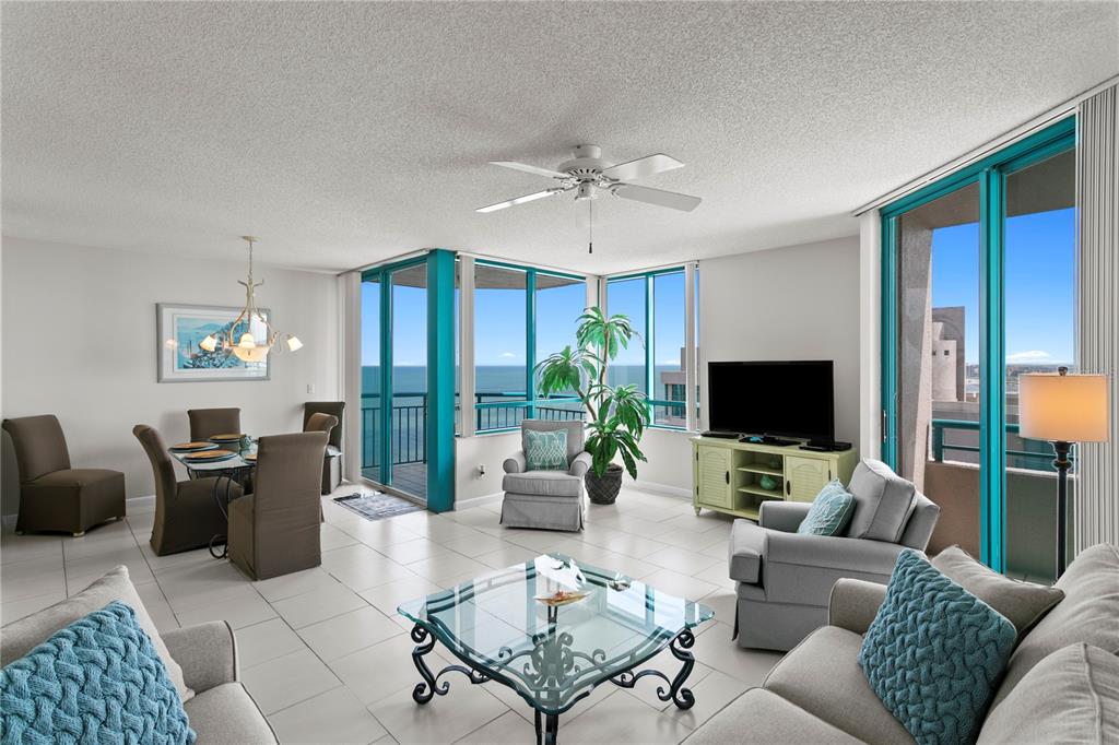 A bright living and dining area with tile floors, floor-to-ceiling windows, and ocean views — 1540 GULF BOULEVARD UNIT 2107, CLEARWATER BEACH, FL
