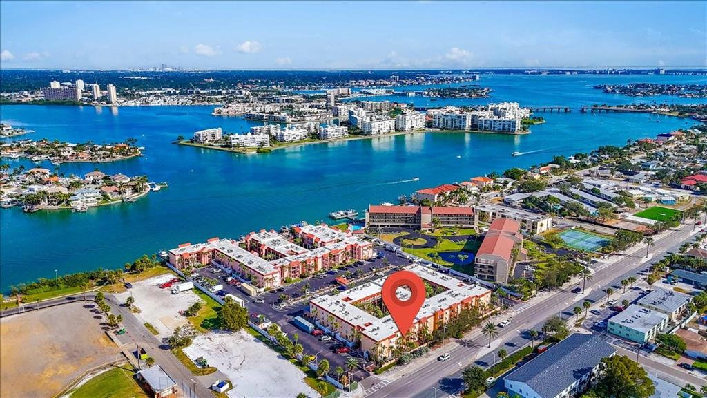 An aerial view shows a multi-story apartment complex with a red location pin — 8911 BLIND PASS ROAD UNIT 209, ST PETE BEACH, FL