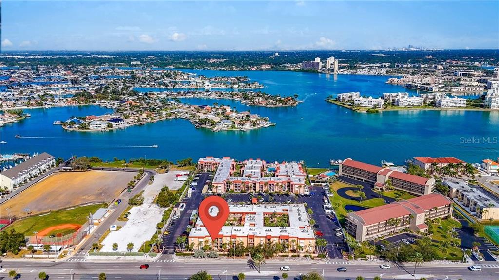 An aerial view shows a multi-story apartment complex with a red location pin — 8911 BLIND PASS ROAD UNIT 209, ST PETE BEACH, FL