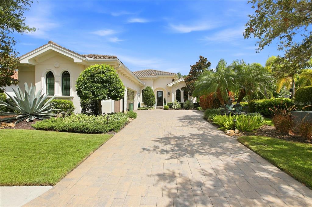 A paved driveway leads to the entrance of a single-story stucco home with landscaping — 7952 MATERA COURT, LAKEWOOD RANCH, FL