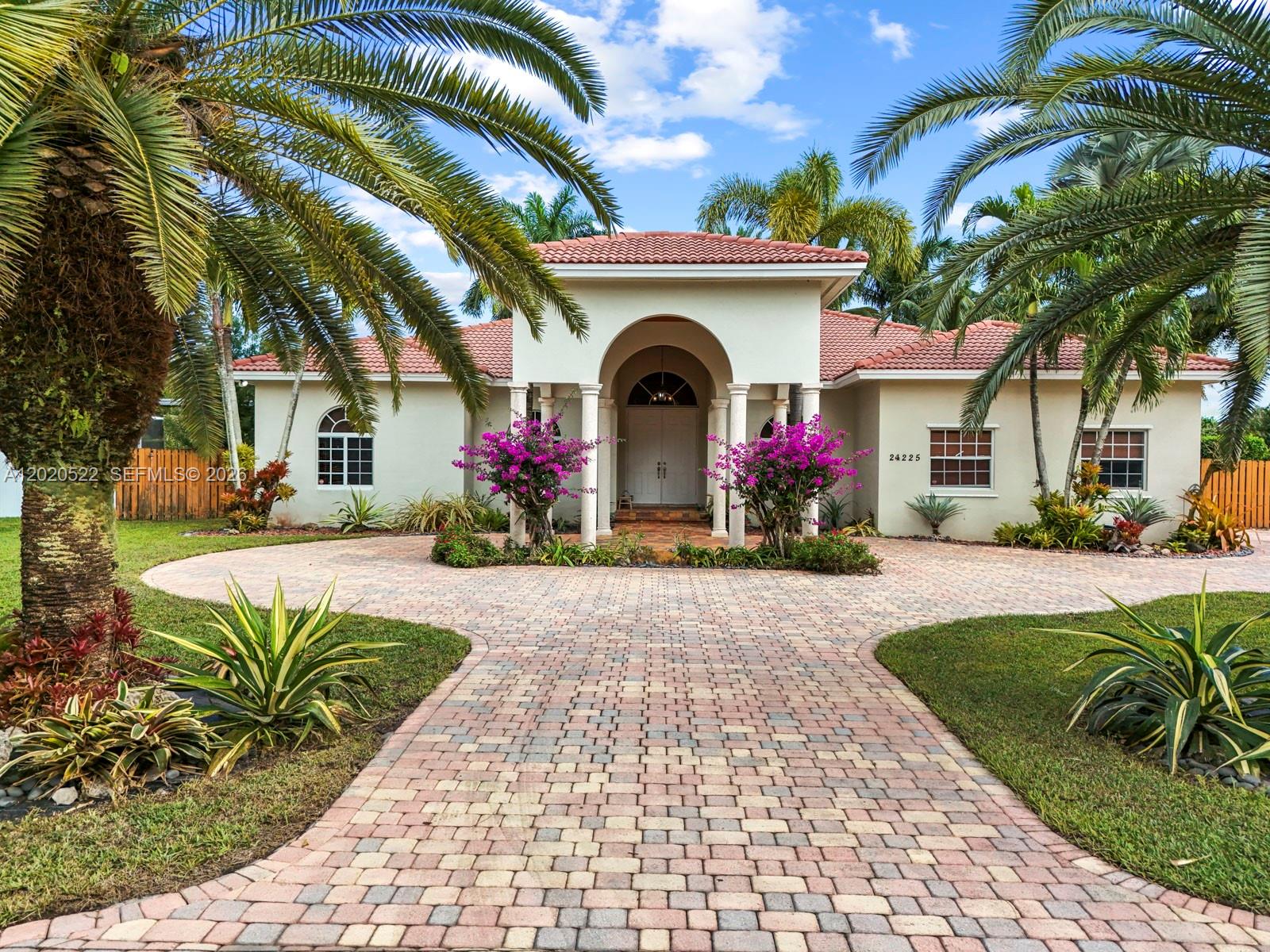 A single-story house with a tiled roof, arched entryway, and a paved circular driveway — 24225 SW 198th Ave, Homestead FL 33031, HOMESTEAD, FL