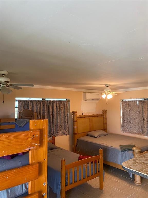 A bedroom contains a bunk bed, a double bed, two ceiling fans, and a wall-mounted AC — 1587 WAYMAN ROAD, MOORE HAVEN, FL