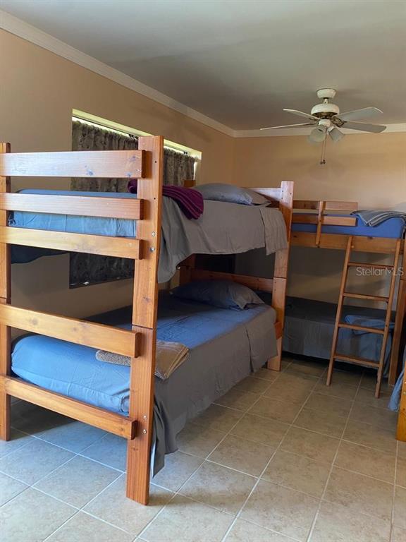 A bedroom features two wooden bunk beds with blue bedding on a tiled floor — 1587 WAYMAN ROAD, MOORE HAVEN, FL