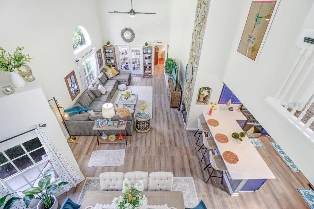 An elevated view of an open-concept living room, dining area, and kitchen with vaulted ceilings — 6049 GENTLE BEN CIRCLE, WESLEY CHAPEL, FL