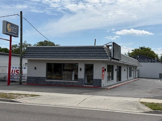 A single-story commercial building with a gray tiled roof and white brick exterior — 9501 N NEBRASKA AVENUE, TAMPA, FL