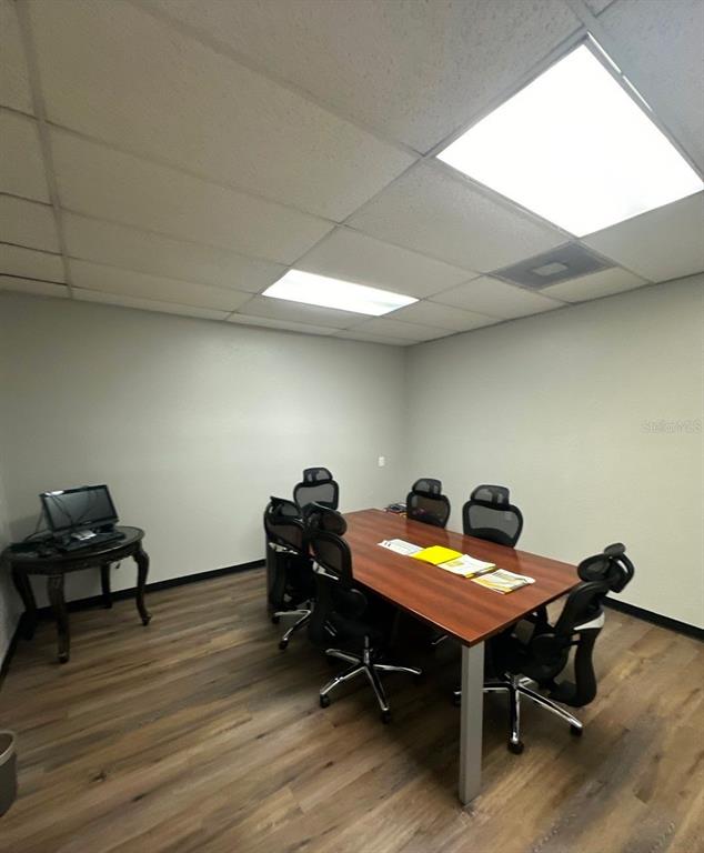 A conference room features a wood-top table, several rolling office chairs, and a small side desk — 9501 N NEBRASKA AVENUE, TAMPA, FL