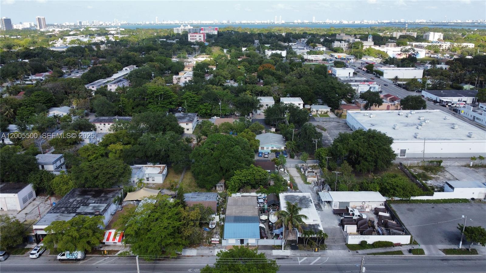 An aerial view shows a commercial and residential area with various buildings and dense trees — 5501 NW 2nd Ave, Miami FL 33127, MIAMI, FL