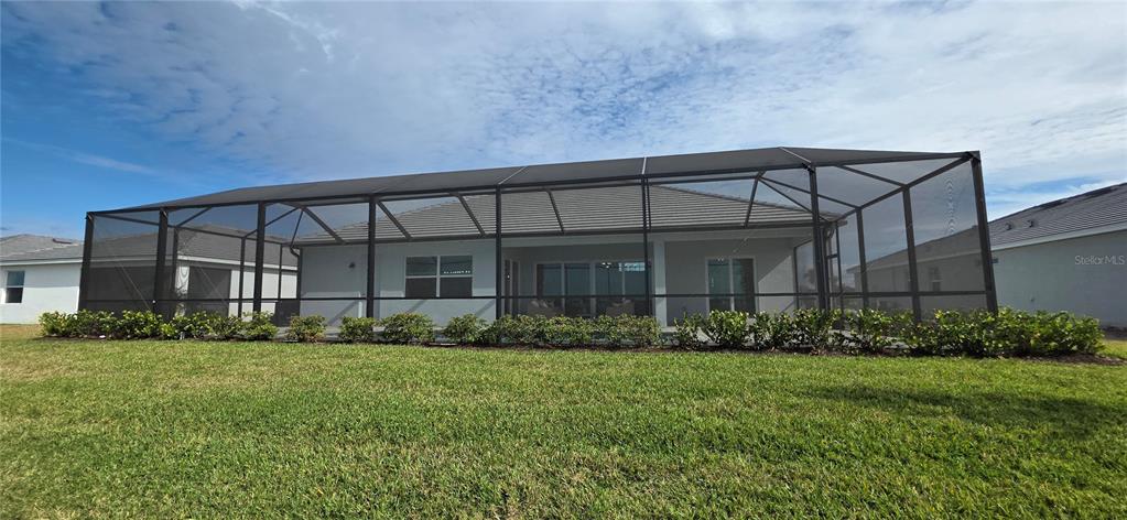 The exterior view shows a house with a screened-in patio and a landscaped backyard — 8140 SHORE LAKE DRIVE, ENGLEWOOD, FL